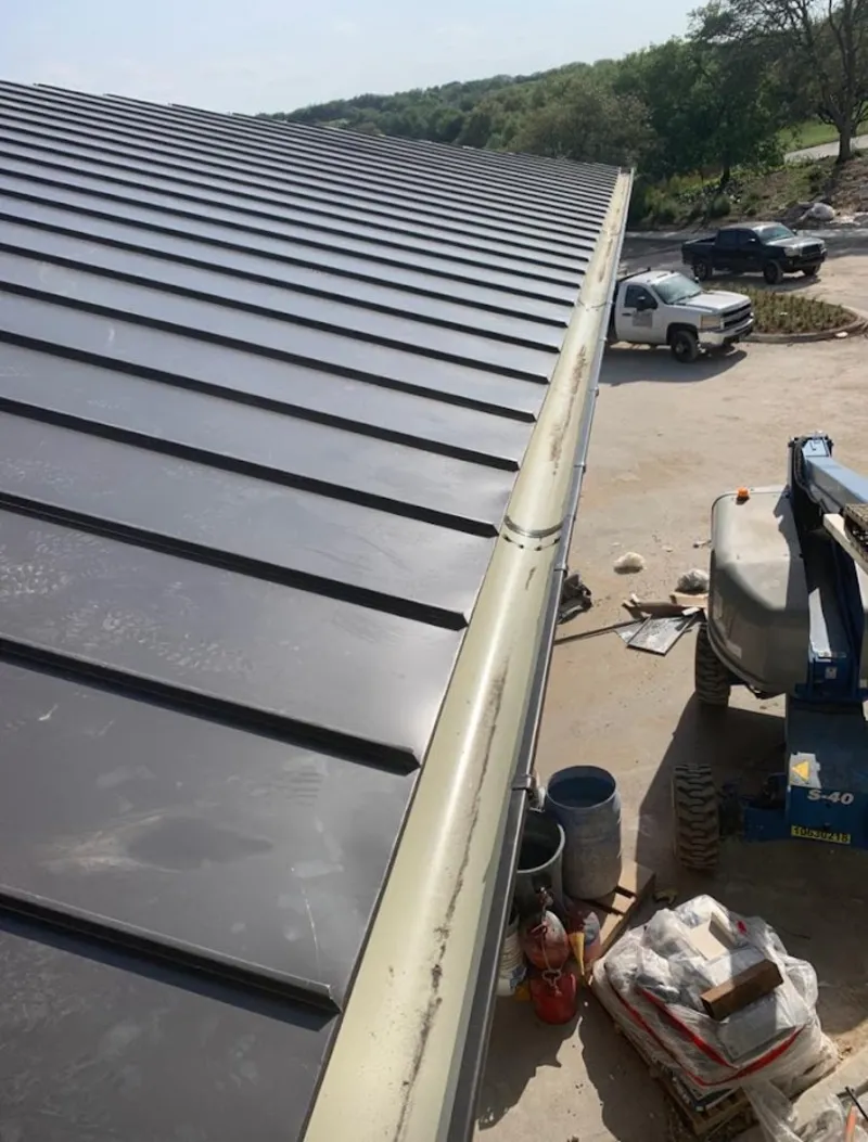 Standing seam panel and gutter detail on a metal roofing jobsite in Ravenna